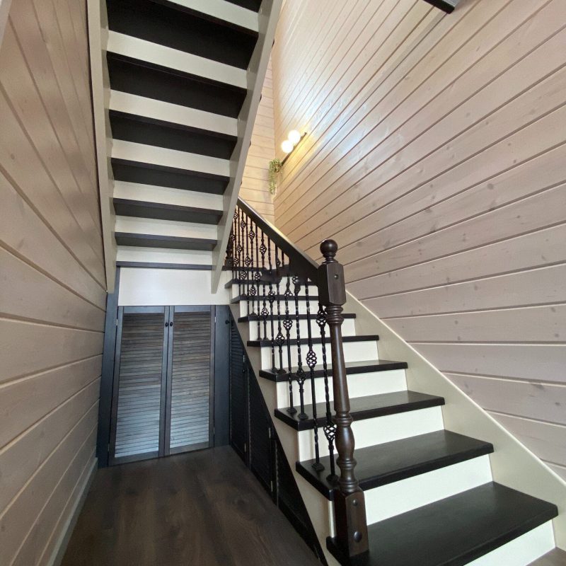 Деревянная лестница из лиственницы с ковкой и кладовкой