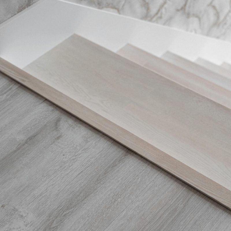 Облицовка бетонной лестницы беленым дубом с доп ступенью на полу