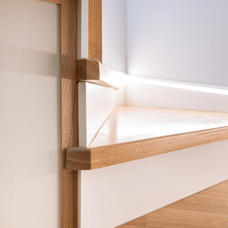 Обшивка бетонной лестницы ясенем с подсветкой в плинтусе