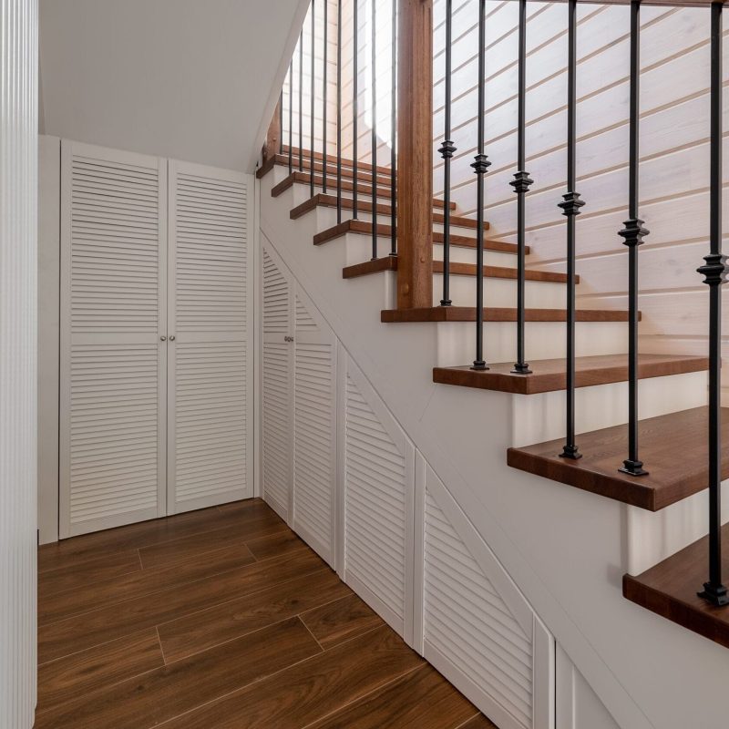 Обшивка металлического каркаса лестницы ясенем в брусовом доме