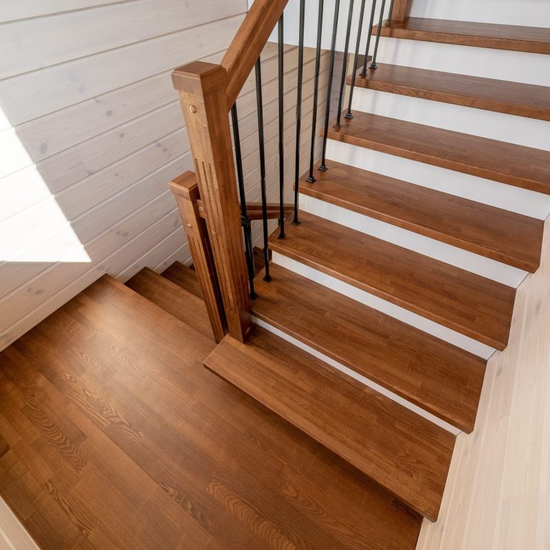 Обшивка металлического каркаса лестницы ясенем в брусовом доме