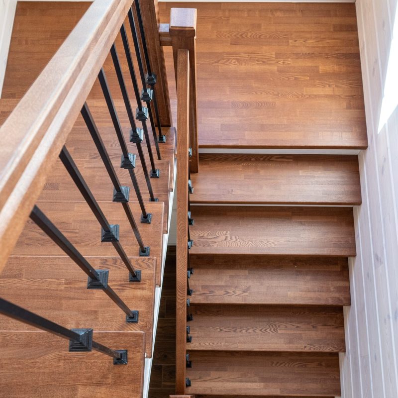 Обшивка металлического каркаса лестницы ясенем в брусовом доме