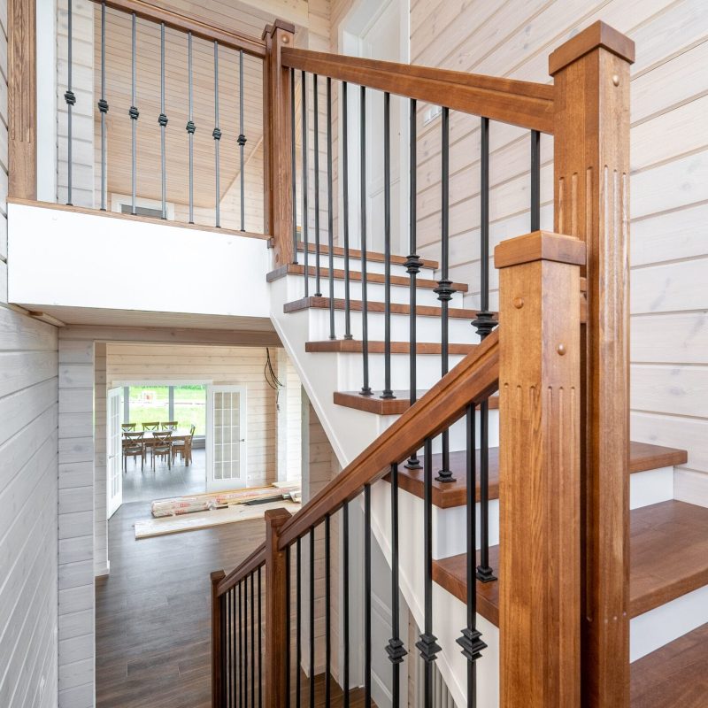 Обшивка металлического каркаса лестницы ясенем в брусовом доме