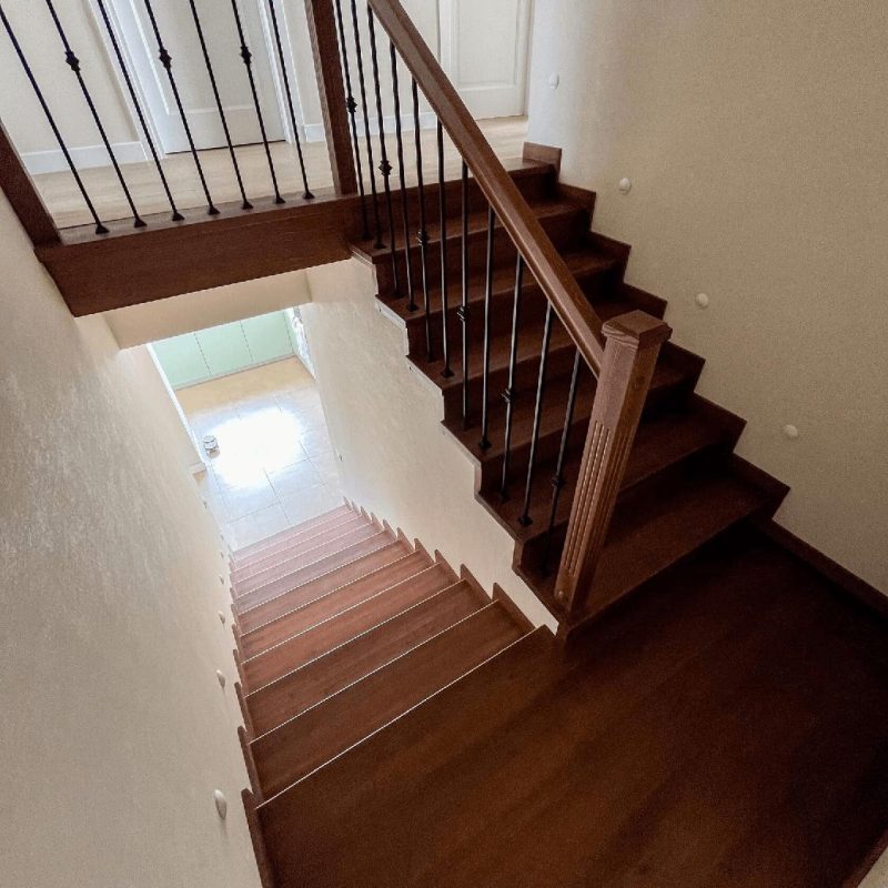 Обшивка однотонной темной бетонной лестницы ясенем