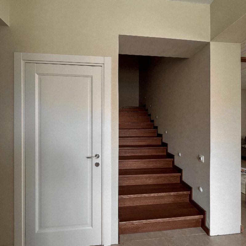 Обшивка однотонной темной бетонной лестницы ясенем