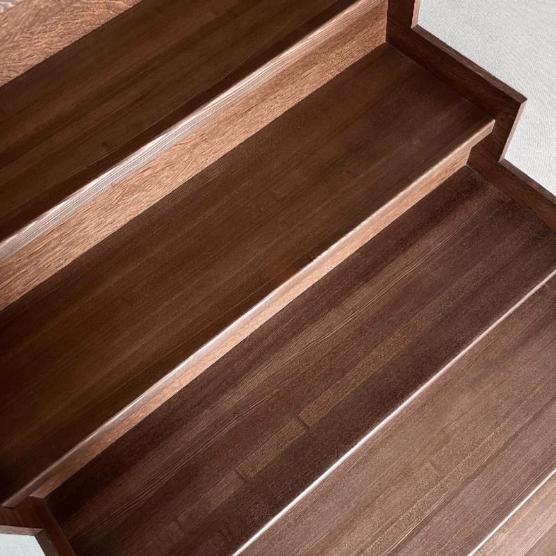 Обшивка однотонной темной бетонной лестницы ясенем