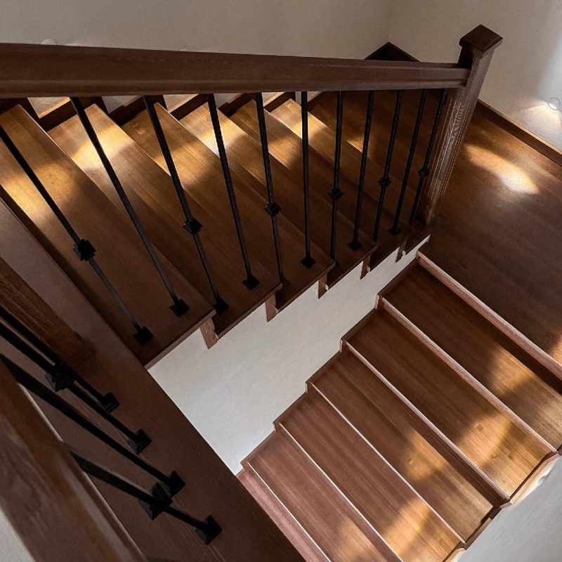 Обшивка однотонной темной бетонной лестницы ясенем