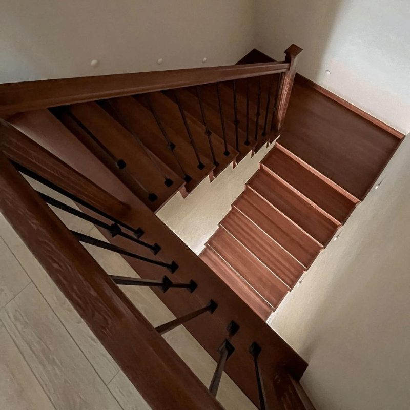 Обшивка однотонной темной бетонной лестницы ясенем