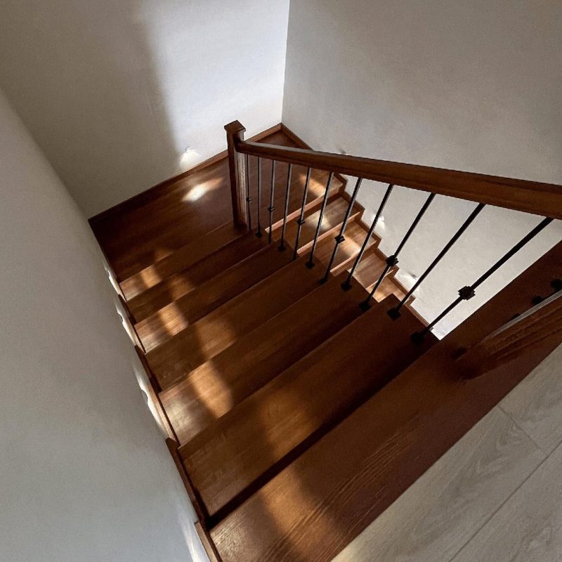 Обшивка однотонной темной бетонной лестницы ясенем