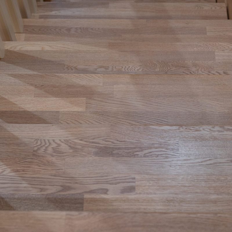 Отделка металлического каркаса лестницы ясенем с ограждением из дерева