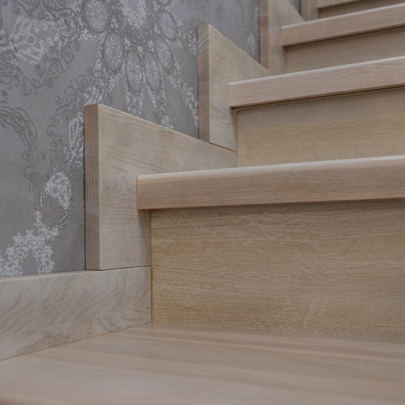 Отделка металлокаркаса лестницы с художественной ковкой дубом