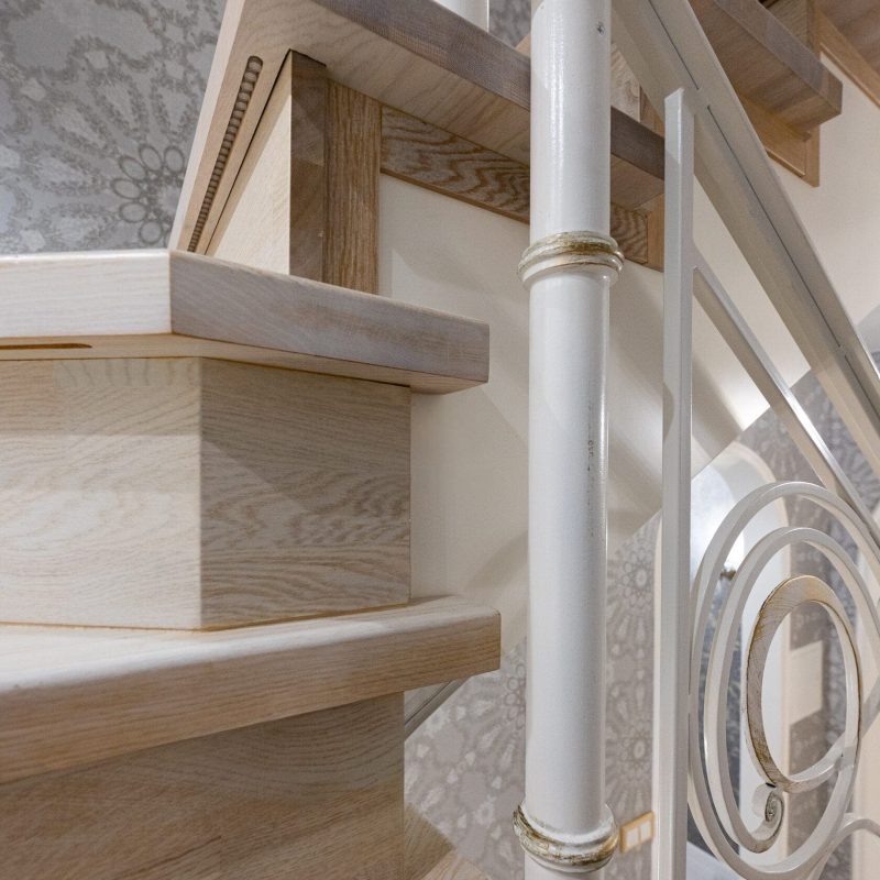 Отделка металлокаркаса лестницы с художественной ковкой дубом