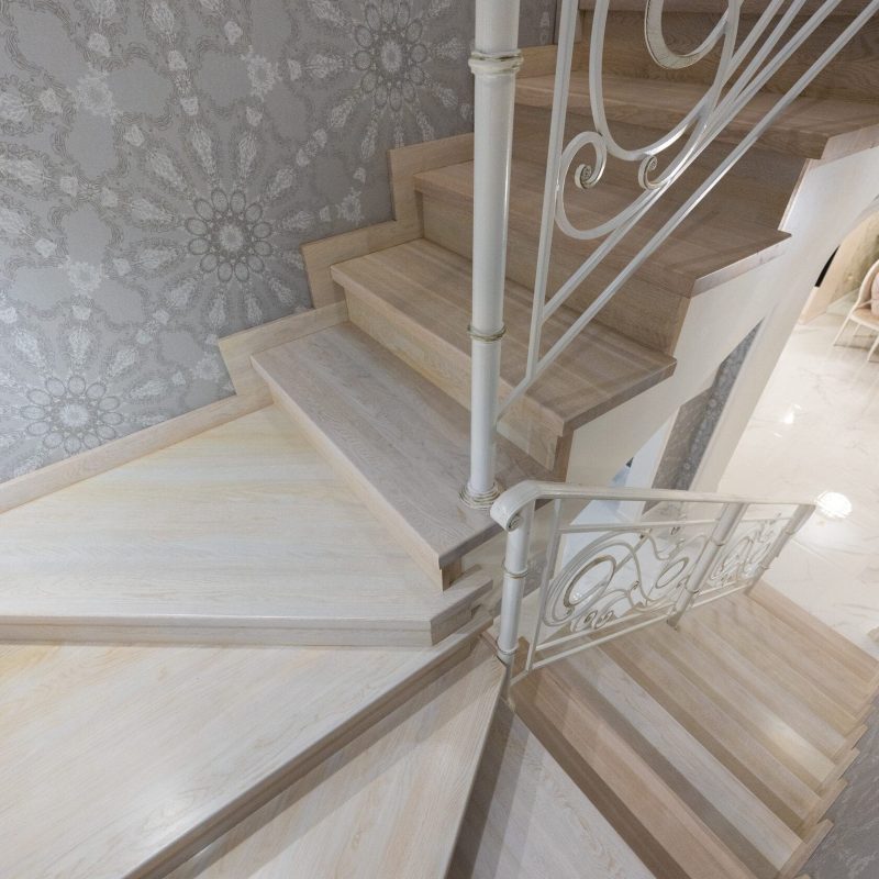 Отделка металлокаркаса лестницы с художественной ковкой дубом