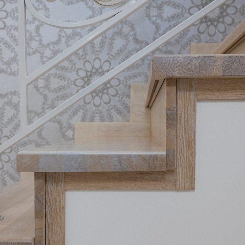 Отделка металлокаркаса лестницы с художественной ковкой дубом