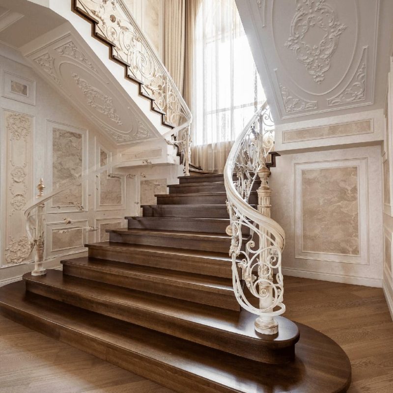 Отделка парадной лестницы из бетона дубом с художественной ковкой