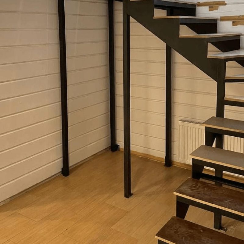 Трехмаршевый каркас забежной железной лестницы в брусовом доме